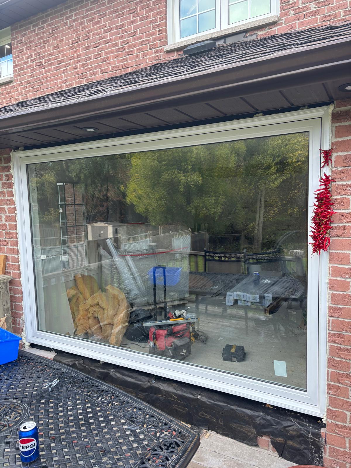 Large picture window installation on a brick home